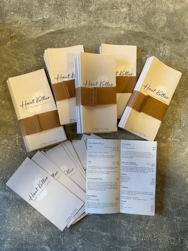 Mehrere Broschüren und Informationsblätter auf einem grauen Untergrund.