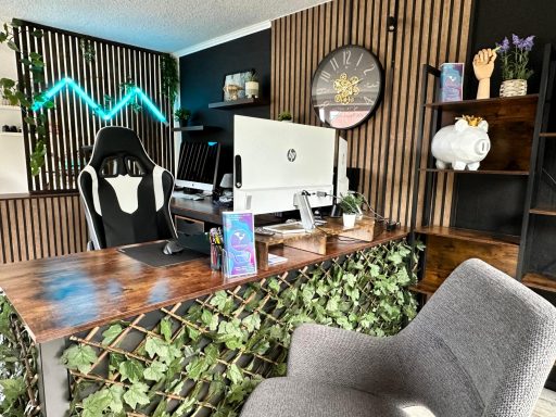 Modernes Büro mit Schreibtisch, Stuhl, Computer und Pflanzenakzenten an der Wand.