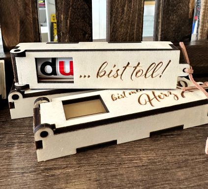 Holzschachtel mit Inschrift „... bis toll!“, dekoriert mit einem kleinen Fenster.