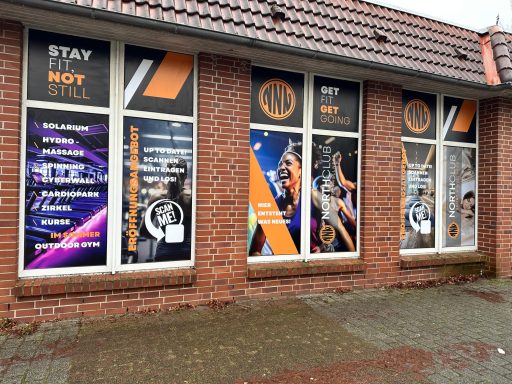 Schaufenster mit Werbung für Sportbekleidung und Fitness, auffällige Farben und Grafiken.