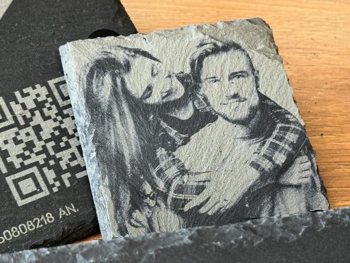 Schwarz-weiße Fotografie von einem Paar, das sich umarmt, auf einer Schieferplatte.