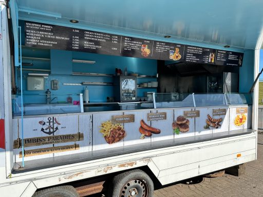 Essensstand mit blauer Fassade und Menü, das Grillgerichte und Snacks anbietet.