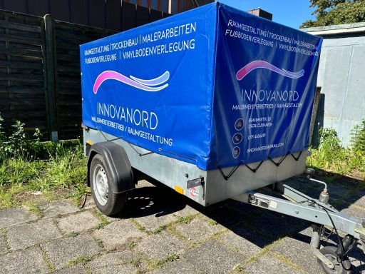 Blauer Anhänger mit Werbung für "WINDMOOD" und Informationen zur Wohlfühlbehandlung.