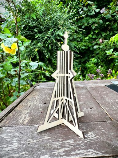 Eine filigrane Holztrophäe mit einem Stern und geometrischen Formen auf einem Tisch.