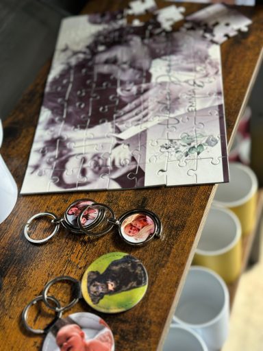 Tisch mit Fotos, Schlüsselanhängern und einem Blatt Papier mit Zeichnungen.