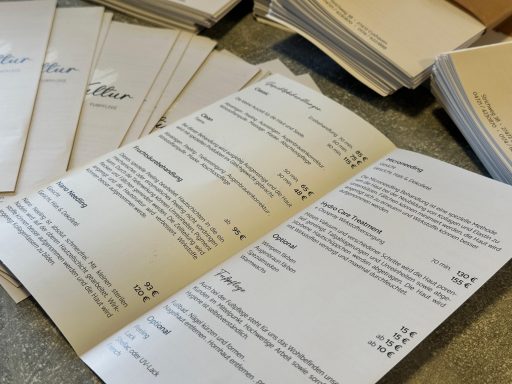 Menü mit verschiedenen Gerichten und Preisen, auf einem Tisch verteilt.